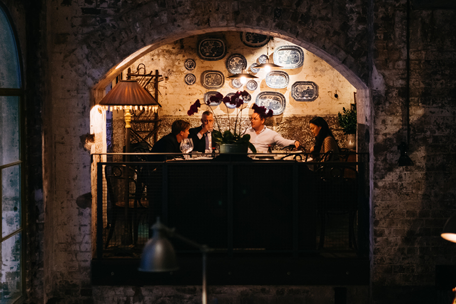 Group of diners talking during a meal at Mr Wong