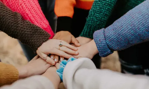 A bunch of hands stacked on top of one another in a huddle