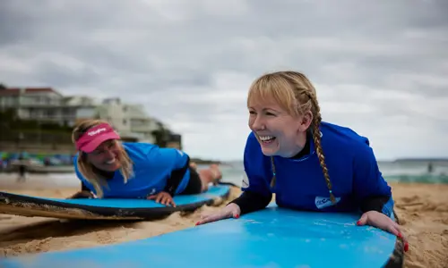 two individuals enjoying a surfing experience as part of their corporate and incentive program