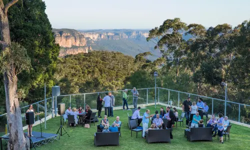 Group of event attendees networking with a view of the Blue Mountains