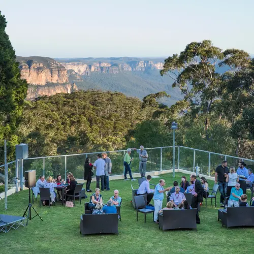 Group of event attendees networking with a view of the Blue Mountains