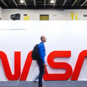 International Astronautical Congress 2025 Attendee Walking across a large NASA Sign