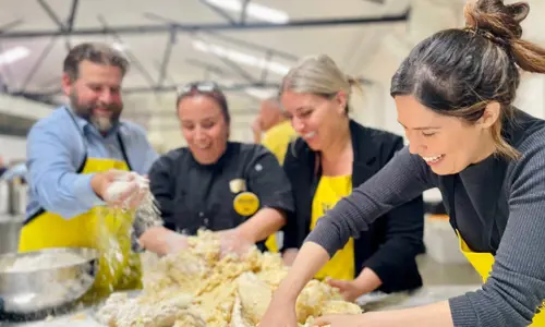 A group of four people preparing food together at OzHarvest