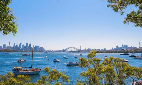 Wide view of Sydney Harbour with Harbour Bridge, city skyline and boats 