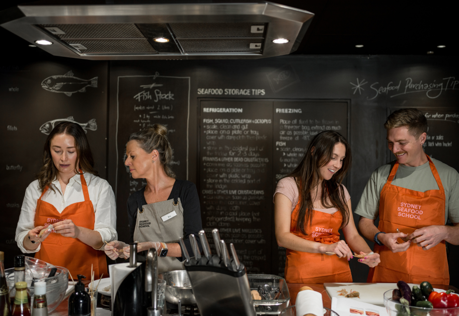 Group of 4 preparing seafood at a cooking class at Sydney Fish Market