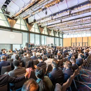 Professional delegates watching presentation while seated at a conference