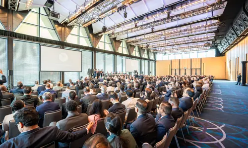 Professional delegates watching presentation while seated at a conference