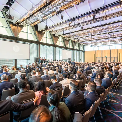 Professional delegates watching presentation while seated at a conference