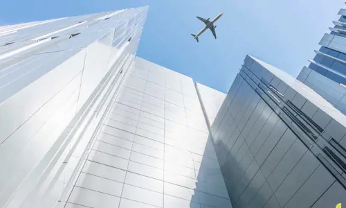 Airplane Flying Over Buildings