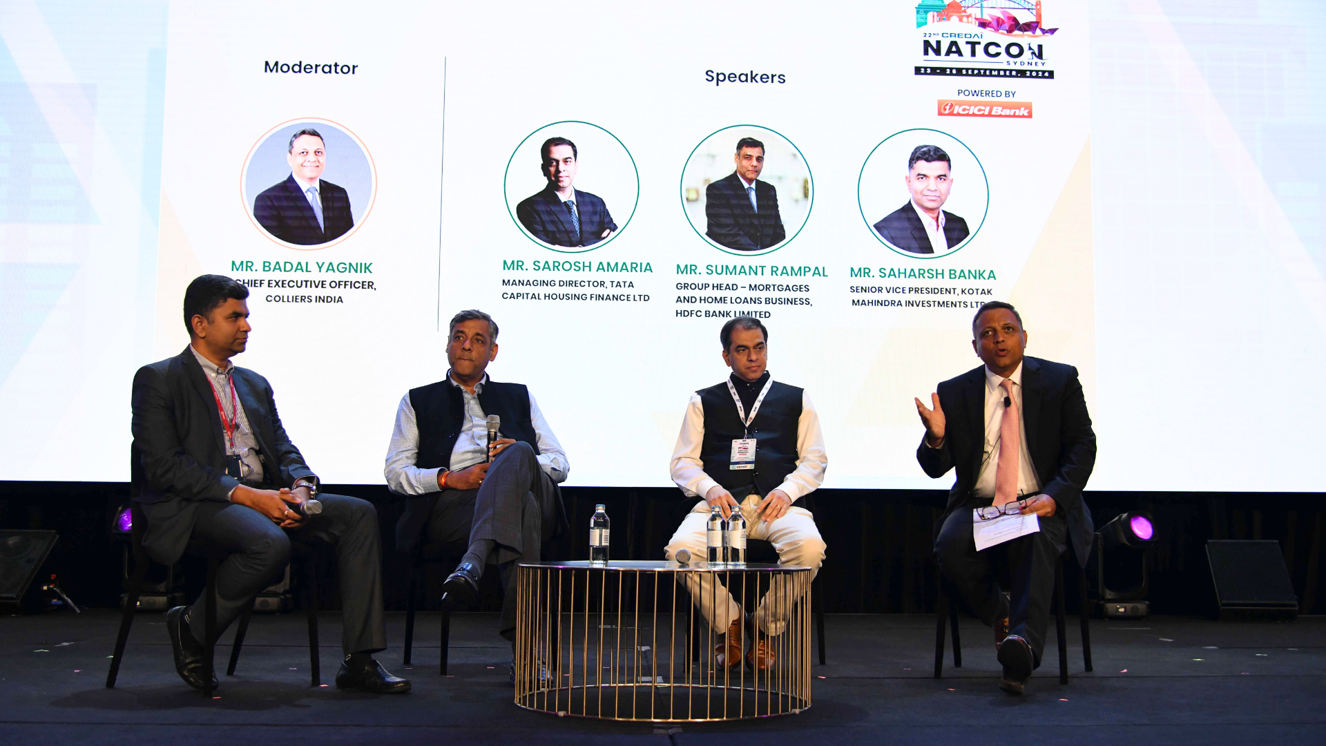 Panel of three speakers and a moderator on stage