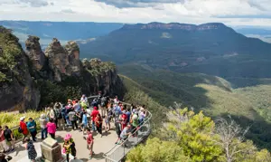 Visitors enjoying panoramic views from a lookout in the Blue Mountains overlooking the Three Sisters and Jamison Valley