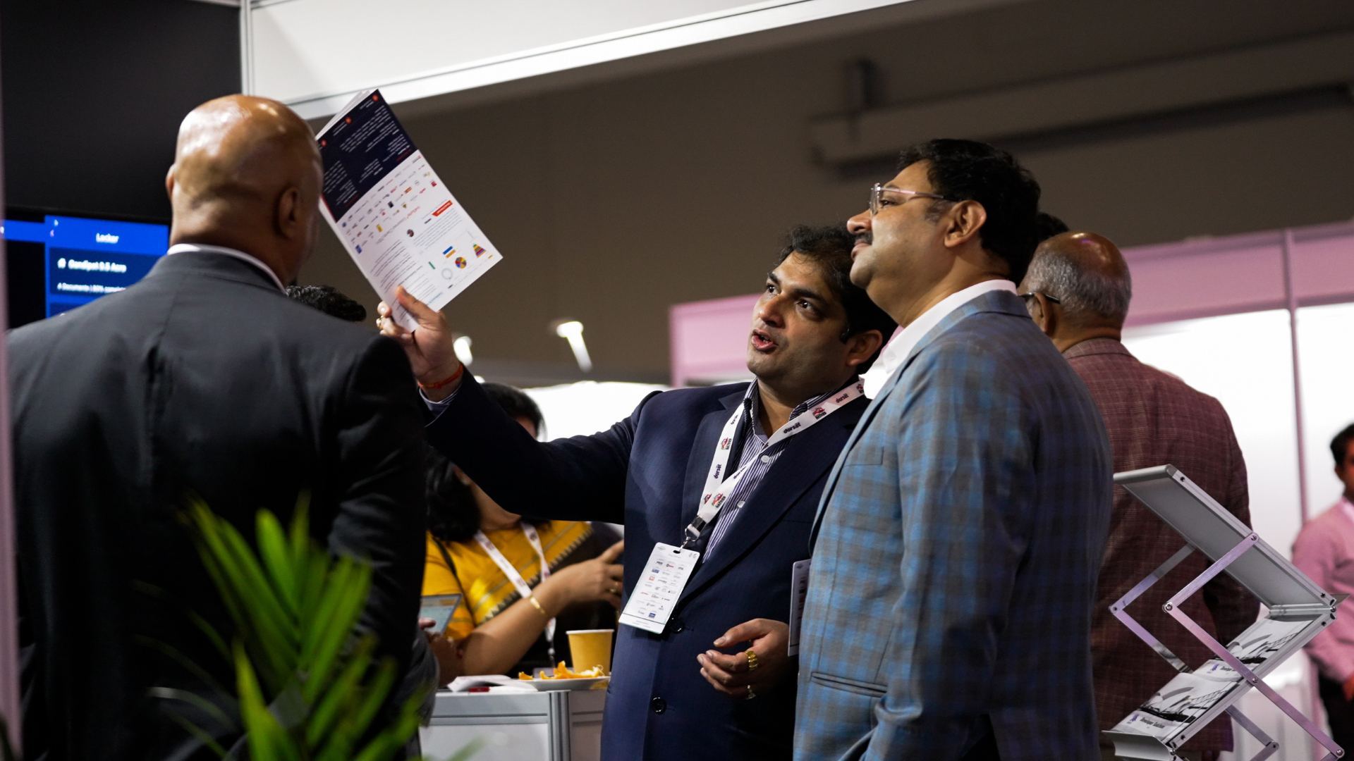 Three delegates in discussion on the expo floor at the Credai Natcon event