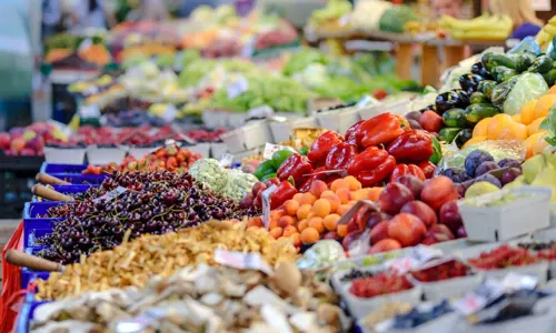Variety of colourful fruit and vegetables laid out for sale at a fresh market